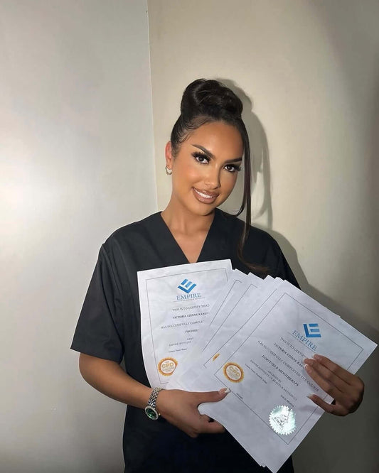 Woman holding certificates from accredited aesthetics courses, showcasing her achievement in aesthetics education.